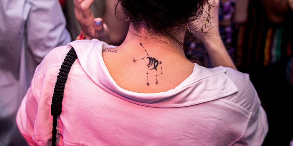 Frau mit Sternzeichen-Tattoo auf dem Rücken